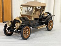 Front three-quarter view of black and tan diecast model, showing details of body, wheels, and hood.