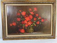 Framed oil painting featuring a bouquet of red roses in a green vase, with a neutral brown background and a gold decorative frame.