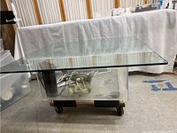 Wide angle photo of aquarium table showing glass top and plexiglass tank below with visible decor inside.