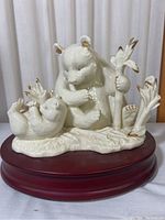 Front view showing adult and cub polar bear with gold accents on ears and paws, on wooden base.