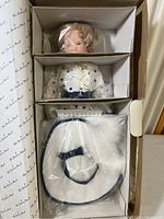 Shirley Temple Bright Eyes doll lying in open box with hat wrapped in plastic inside the box, doll appears to be in excellent condition though box is damaged