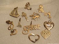 Photo of all 12K gold charms showing various designs including animals, letters, and heart shapes.