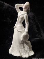 Front and side view of the Royal Doulton porcelain figurine showing white dress and Christmas garland in hand.
