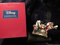 Figurine displayed next to Disney Showcase Collection red box showing Mickey and Minnie ice skating