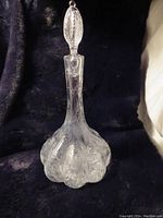 Front view of the etched cut crystal decanter with detailed leaf patterns visible on body and stopper. Clear, unblemished glass with no chips or cracks.