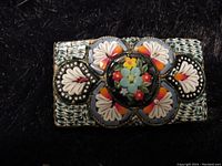 Close-up of rectangular sterling silver pin showing detailed micro mosaic floral design in multiple colors with central bouquet of tiny flowers surrounded by petal motifs.