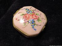 Top view of square pink Limoges trinket box with hand-painted floral design and gold trim.