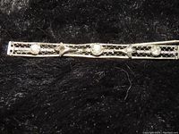 Close-up of one vintage rhinestone barrette showing the lattice metalwork and three clear rhinestones on black background.