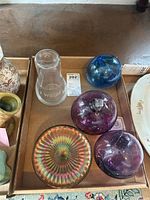 Top-down view of the glass spheres, iridescent bowl, and water container arranged in a tray