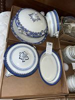 Top view of covered casserole dish with lid, oval serving trays, and lidded casserole dishes arranged in a box