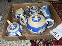Four items (teapot, creamer, sugar bowl with lid, vase) in cardboard box on bubble wrap