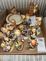 Overview of all 12 Hummel figurines in a box showing various children characters and different poses.