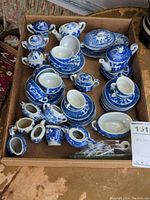 Overview photo of the Japanese blue and white porcelain tea sets including teapots, cups, saucers, creamers, serving plate and spoons arranged in a box.