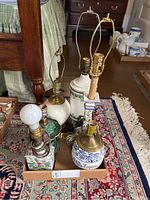 Photo showing all six table lamps arranged on a patterned rug, highlighting variation in bases and absence of shades.