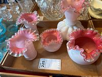 Five pink and white opalescent vases with ruffled clear edges arranged in box