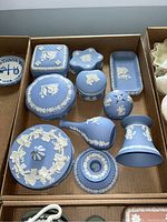Top view of blue Wedgwood jasperware boxes and decorative objects in a cardboard box