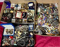 Three cardboard trays filled with various jewelry pieces