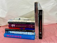 Stack of books showing titles including The Inuit Imagination, The Art of Hanukkah, Rembrandt, The Magic of M.C. Escher, Cassatt, Matisse, and The Tangled Garden.