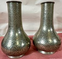 Front view of the pair of hammered pewter vases showing their distinctive textured finish and shape.