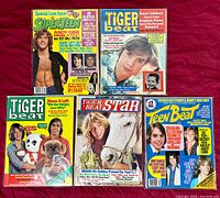Five vintage magazines laid out on a red surface showing covers of Teen Beat and Tiger Beat from 1977-78.