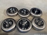 Six small round silver peel back stick-on lights with clear lenses over LEDs, shown from the top.