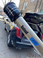 Close-up photo of the Bushnell logo on the silver telescope tube with black eyepiece.