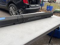 Side view of the Sony sound bar, showing the overall length and shape with attached power cord.