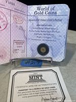 Open Certificate of Authenticity booklet showing coin in capsule and passport-style pages