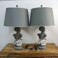 Front view of the pair of vintage lamps with paperboard shades and composite bases showing the floral and swirl design in blue gray and ivory white.