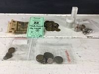Full overview of assortment including paper currency, coins, and several small bags with tokens.