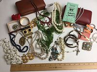 Overview of all costume jewelry items and jewel boxes displayed with ruler for scale.