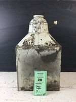 Front view of heavily worn and rusted Hoosier flour sifter with white paint partially remaining and crank handle visible.