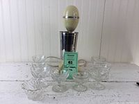 Front view of Hamilton Beach Drink Master mixer with 8 glass ice cream dishes and small bowl arranged in front.