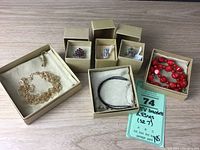 Photo showing all boxed rings and bracelets arranged on a wooden surface, confirming items new in boxes.