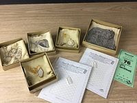 Full view of all 7 necklaces in individual boxes along with certificates or paperwork.