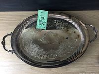 Front view of the oval silverplate tray with etched detail and handles.