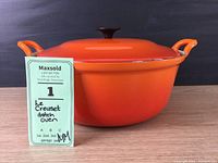 Front view of orange Le Creuset Dutch oven with MaxSold tag