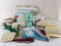 Wide view of assorted vintage lace, ribbons, and trims spread on a white surface.