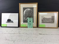 Overall view of three framed black and white art pieces on a surface, showing variety in frame colors and art styles.