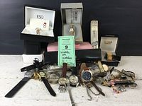 Image showing multiple wristwatches with original branded boxes ESQ and Seiko, plus loose watches and a pink case watch surround.