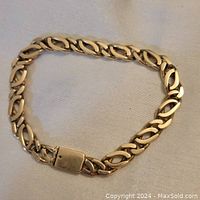 Bracelet laid flat on fabric background showing full length and link style.