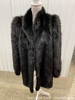 Front view of black fur coat on dress form