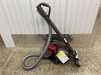 Full view of Dyson canister vacuum with hose coiled and extension wand attached