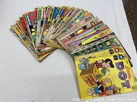 Many vintage comic books laid out fanned, predominantly Archie related titles such as Archie Giant Series, Little Dot, Richie Rich, Jughead, and others.
