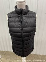 Front view of Stormtech black quilted sleeveless vest with zippered front and high collar.
