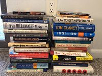 Additional books stacked showing titles such as How to Get Happily Published, Tom Clancy Code of Honor, Million Dollar Blackjack, and Poker for Dummies.