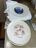 Top plate with blue Wedgwood design and below stack of Ranck's United Methodist Church plates with printed illustrations