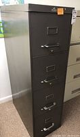 Side and front views of the grey 4 drawer metal file cabinet, showing handles, label holders, and lock feature on drawers.