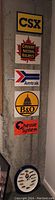 Five train signs vertically mounted on a wall: CSX, Canadian National Railways, Amtrak, B&O, Chessie System. Lionel train clock below them.