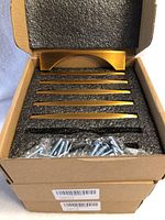 Three boxes stacked containing antique brushed brass finish cabinet drawer pulls and mounting screws inside boxed foam insert.